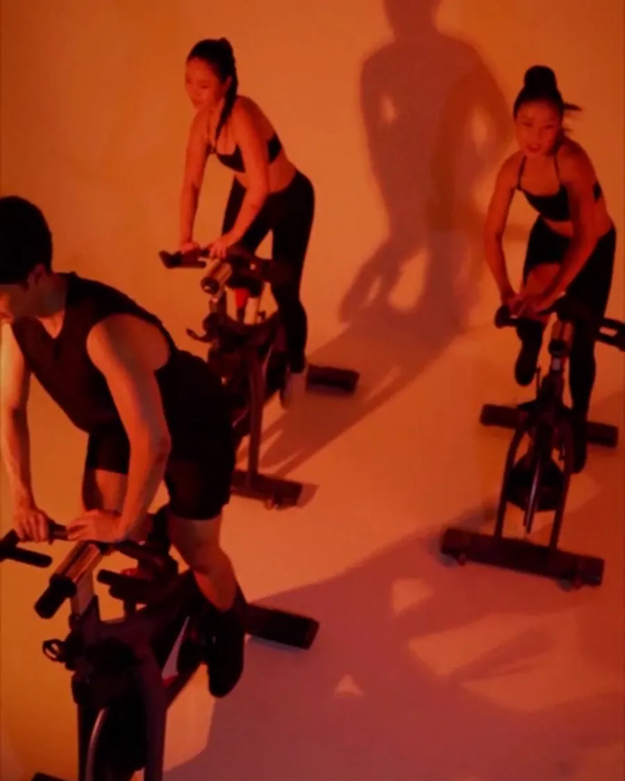 A room of riders lit amber during a class.