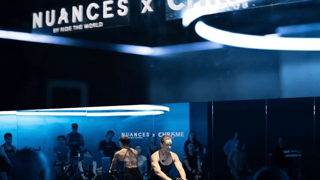 Riders on the floor at the Nuances x Chrome Club event, lit blue.