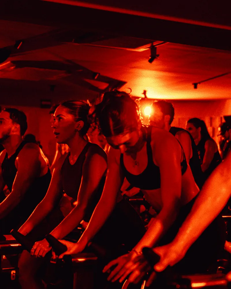 A pack of riders lit red during a Global Flow class.