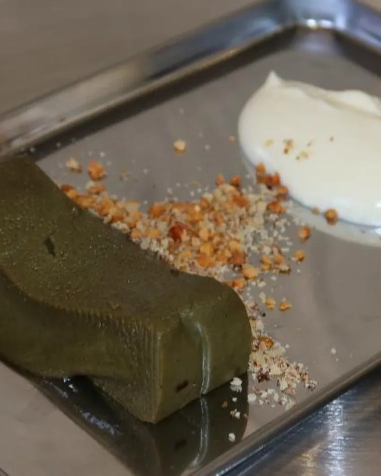 A tea terrine plated with nut crumbles and whipped cream.